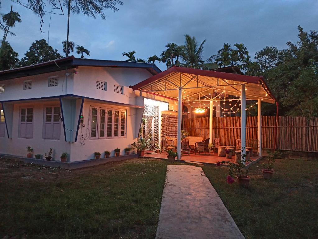 ein Haus mit einer Pergola im Hof in der Unterkunft Assam Villa - by Storyweavers Retreat in Jorhat