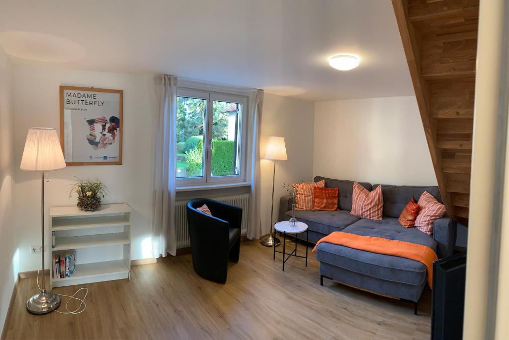 sala de estar con sofá azul y ventana en Chalet zum See, en Bregenz