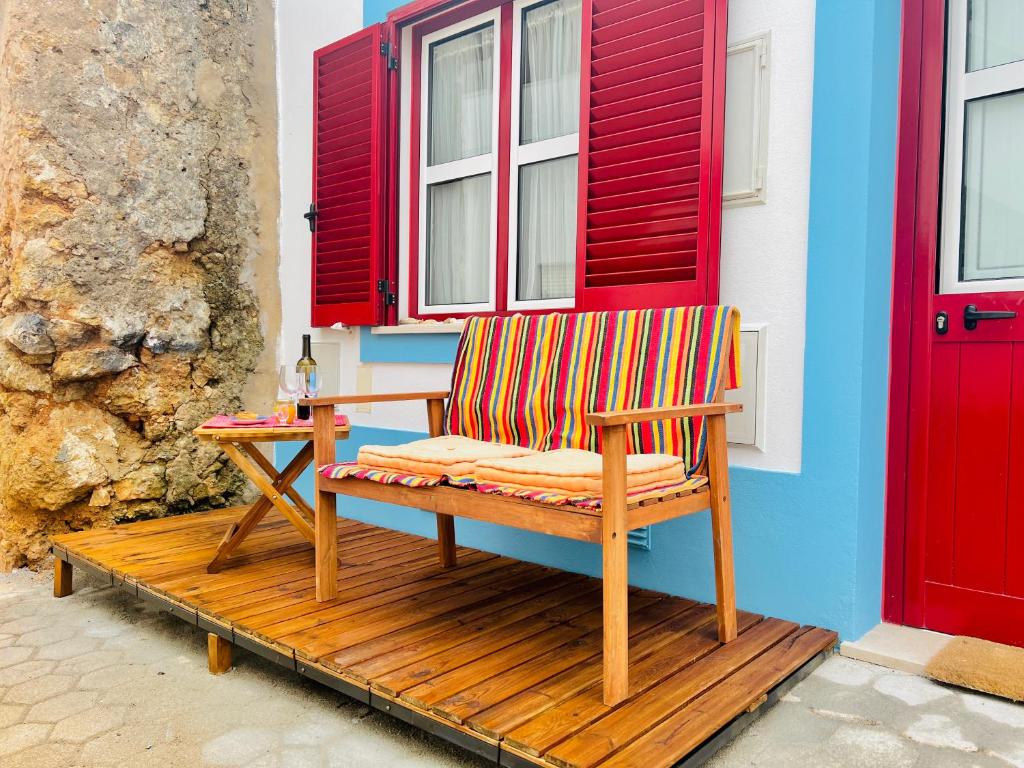 Eine Holzbank steht auf einer Veranda neben einem Fenster in der Unterkunft CASA BIKAS in Barão de São Miguel