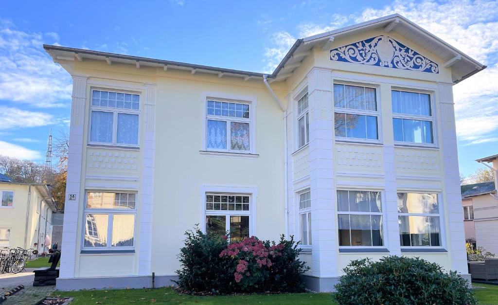 a white house with windows on a street at Ferienhaus Pank in Heringsdorf