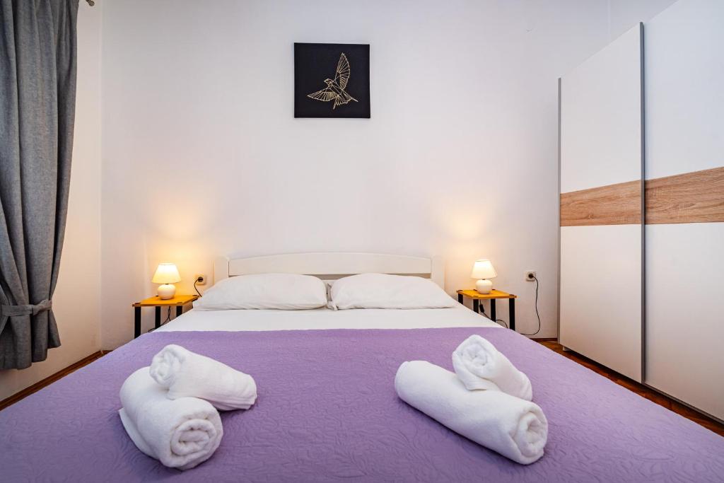 a bedroom with a bed with white towels on it at Apartment Eva in Maslenica