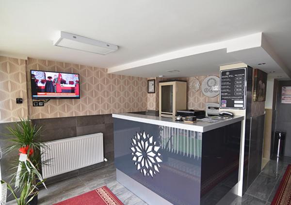 a kitchen with a counter and a tv on the wall at Saltuk Hotel in Erzurum
