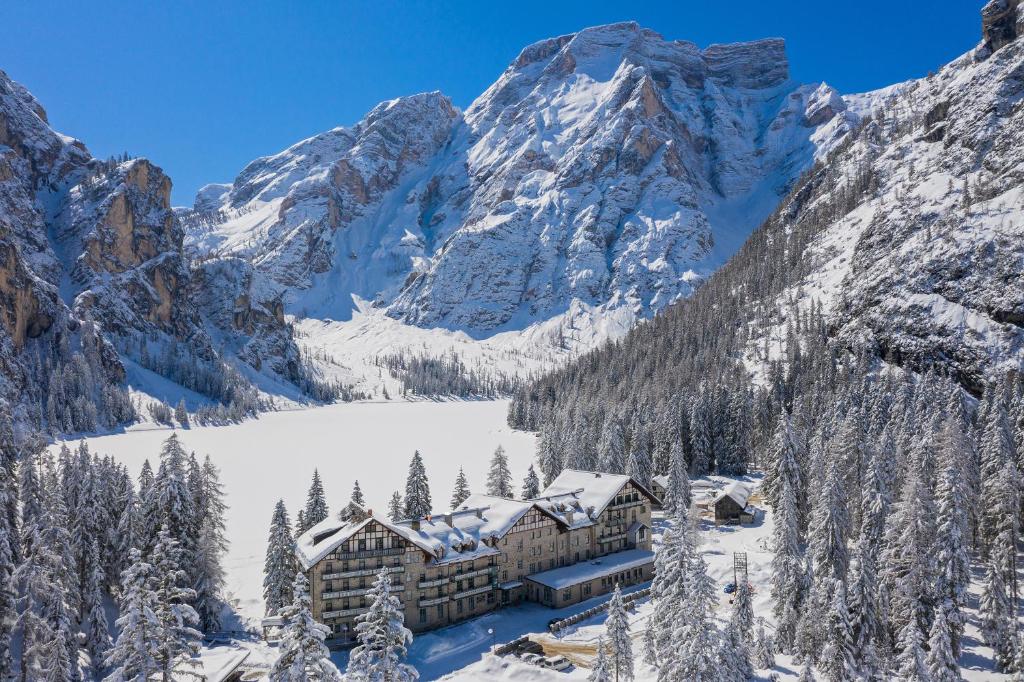 a hotel in the mountains with snow covered mountains at Hotel Lago di Braies in Braies