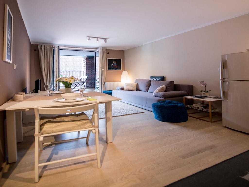 Il comprend une cuisine et un salon avec une table et un canapé. dans l'établissement Apartament Nad Wisłą, à Cracovie