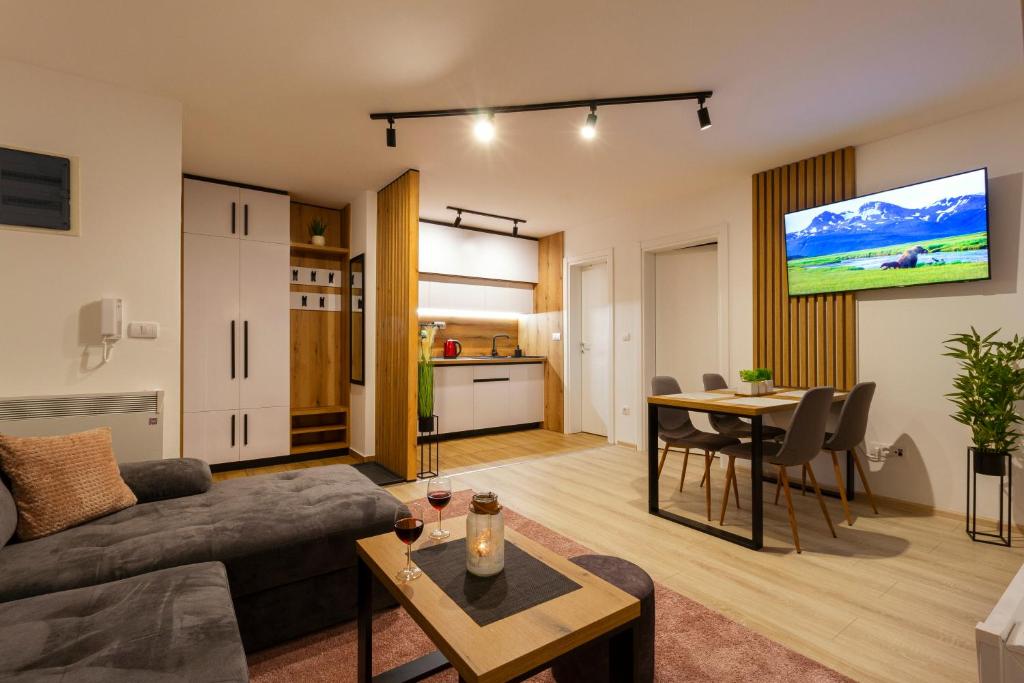 ein Wohnzimmer mit einem Sofa und einem Tisch in der Unterkunft Ema apartman - Zlatar in Nova Varoš