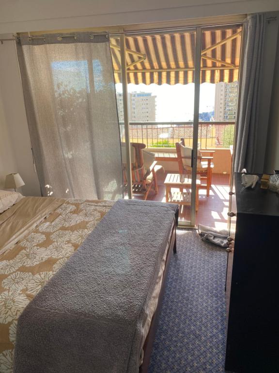 a bedroom with a bed and a balcony with a table at Une terrasse sur Monaco logement 2 chambre in Beausoleil