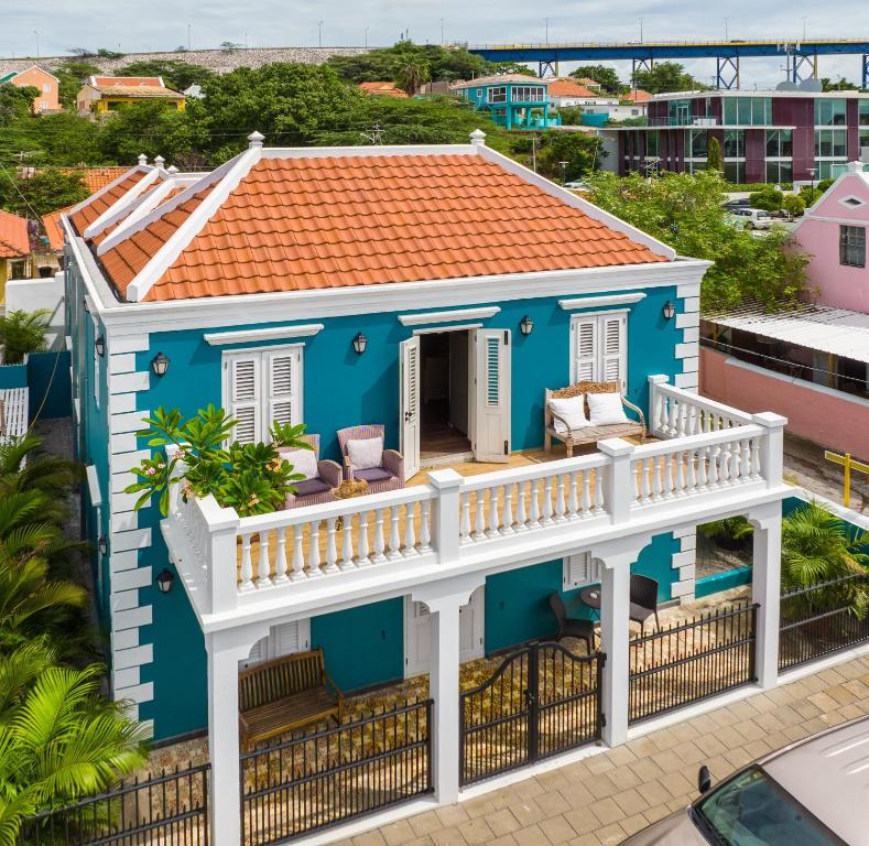 a blue house with a deck and balcony at Curaçao Gardens in Willemstad