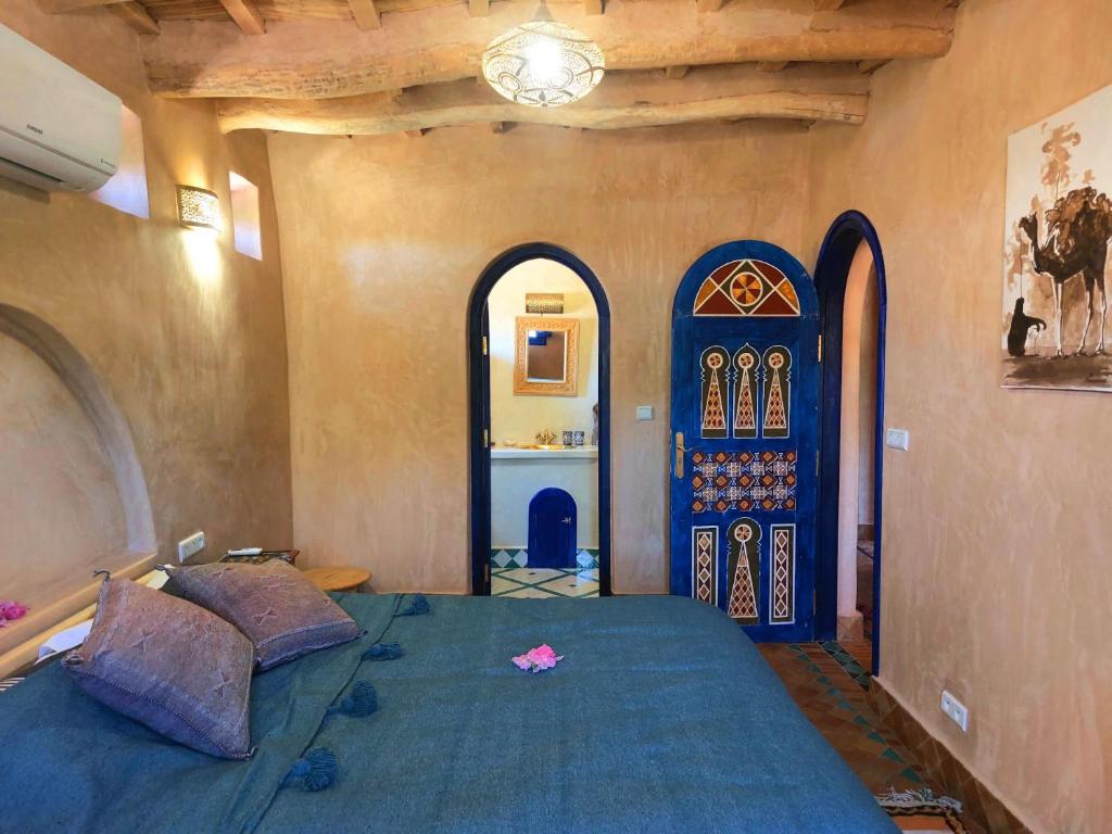 エル・ケラーア・デス・メグナにあるBab El Atlasのベッドルーム1室(青いベッド1台、青いドア付)