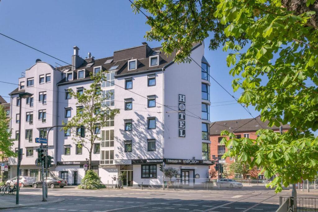 duży biały budynek przy ulicy miejskiej w obiekcie HOTEL Am Spichernplatz w mieście Düsseldorf