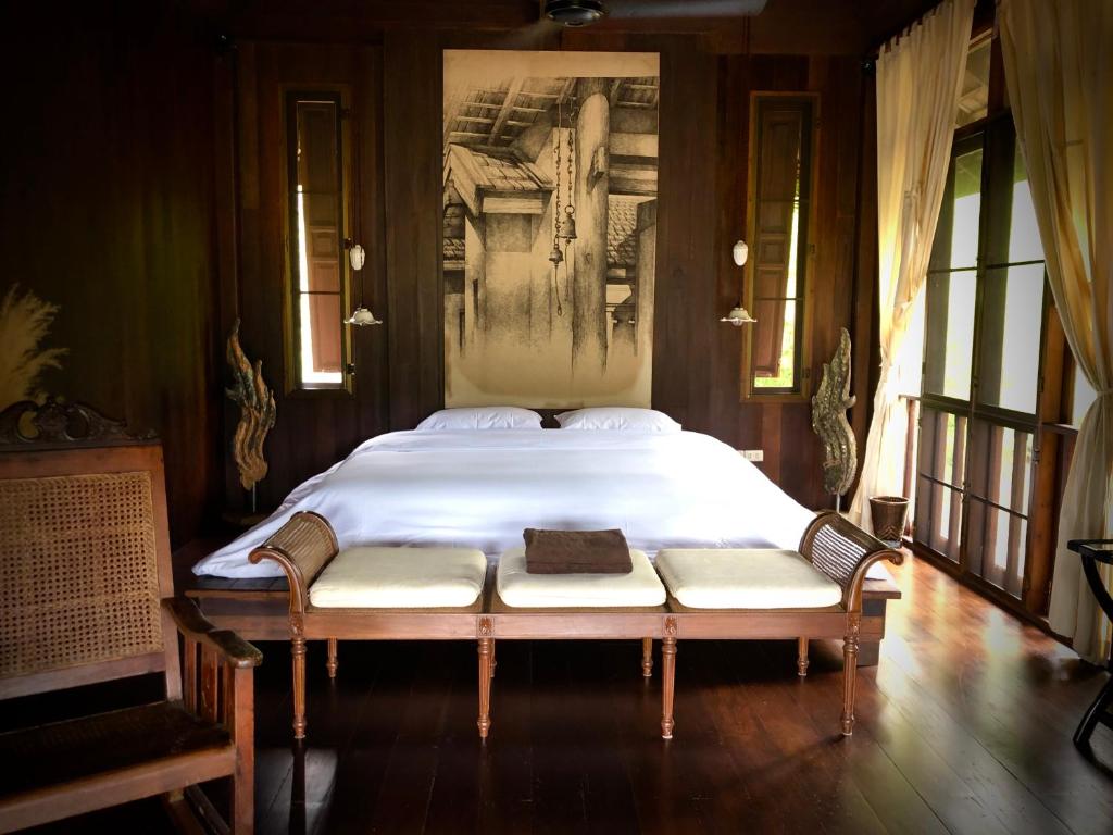 - une chambre avec un grand lit orné d'une peinture murale dans l'établissement Ma Maison Khaoyai, à Ban Sap Bon