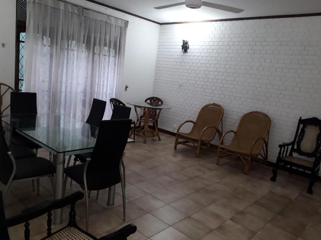 d'une salle à manger avec une table, des chaises et un mur en briques. dans l'établissement Ceylon Travel and Stay Lodge, à Battaramulla