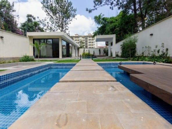 a swimming pool in front of a house at Avana studio in Nairobi