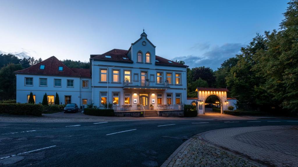 une grande maison blanche avec une porte voûtée dans l'établissement Hotel Wittekindsquelle, à Bad Oeynhausen