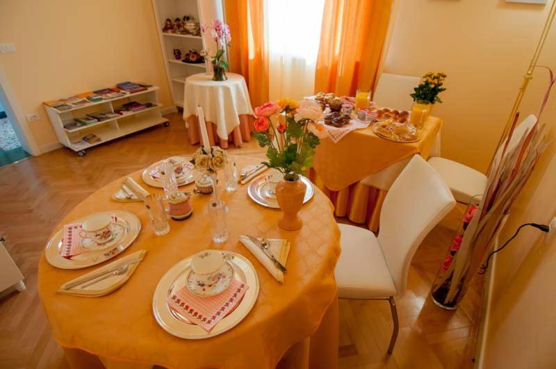 una sala da pranzo con tavolo, piatti e stoviglie di B&B Gasiso a Monfalcone