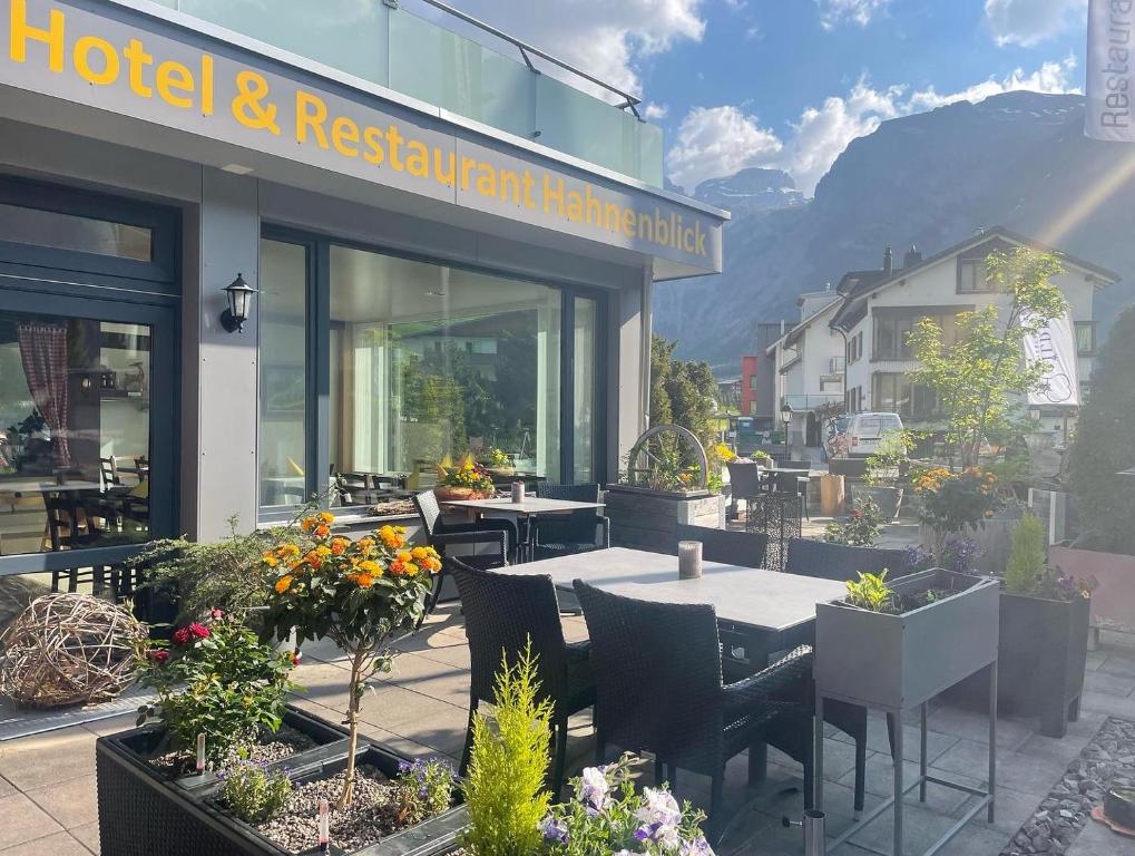 un restaurant avec des tables et des chaises en face d'un bâtiment dans l'établissement Hotel Hahnenblick, à Engelberg