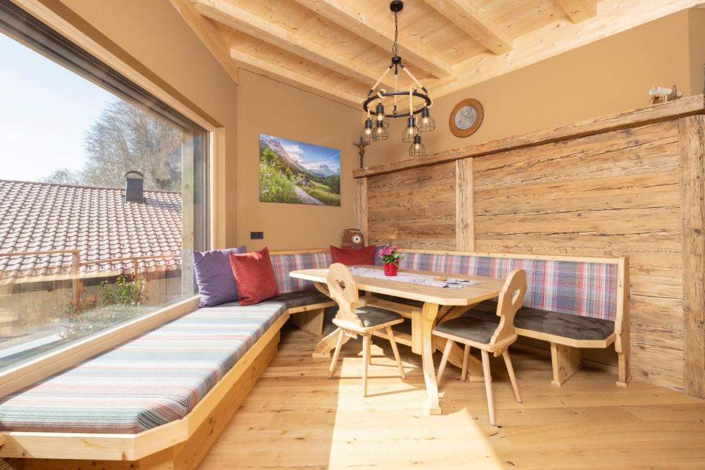 a dining room with a table and chairs and a large window at Bio-Chalet Haus Wagner in Niederndorf