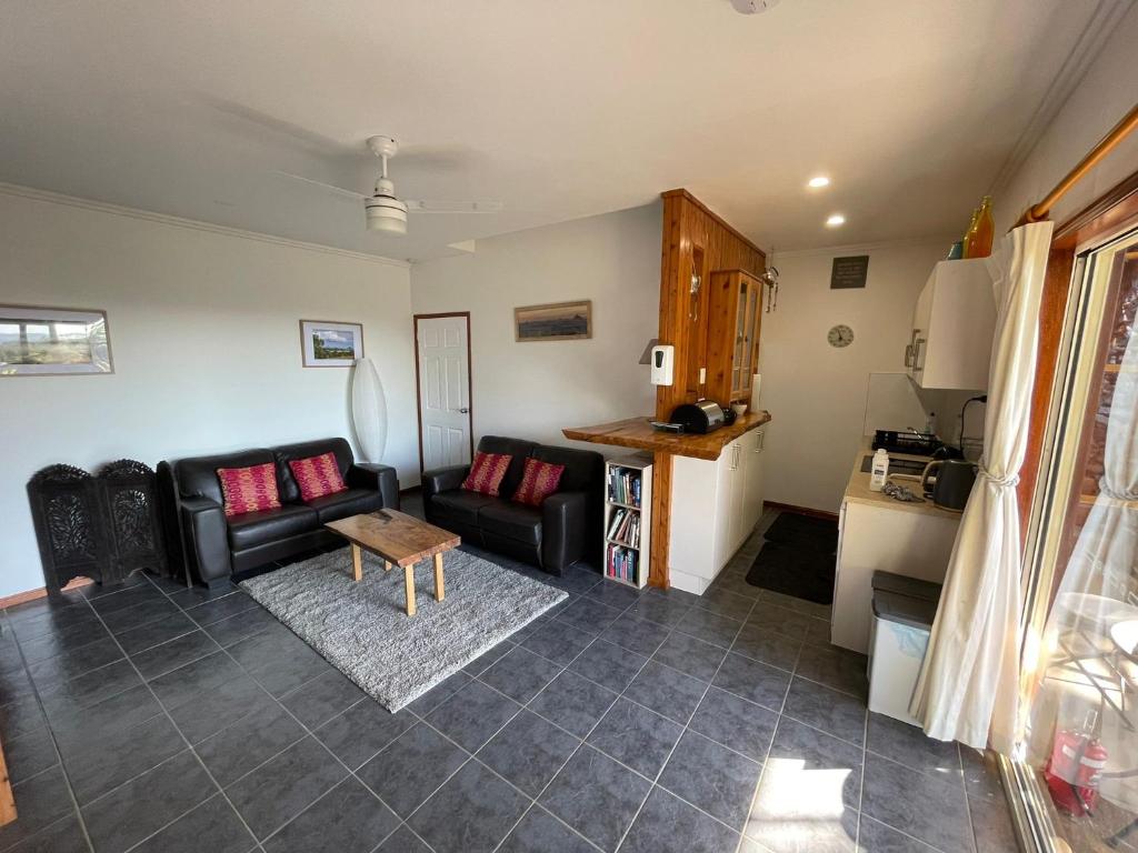 a living room with a couch and a table at Tunnel Ridge Outlook in Mooloolah