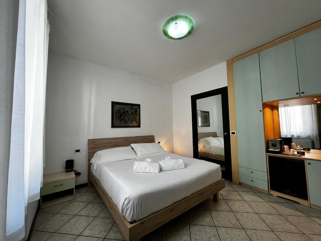 a bedroom with a white bed and a mirror at Casa Carlotta in Follonica