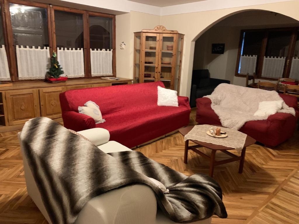 a living room with a red couch and a chair at Villa Tancredi in Courmayeur