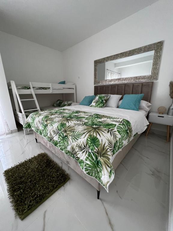 1 dormitorio con 1 cama grande y espejo grande en apartment Julija en Okrug Donji