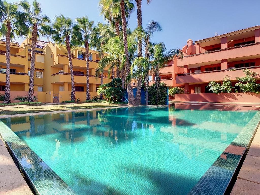 a swimming pool in front of a building with palm trees at Arona 2 - 5907 in Mar de Cristal