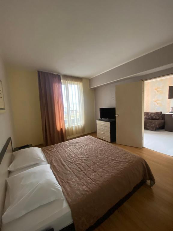 - une chambre avec un lit et une grande fenêtre dans l'établissement Diva Apartments & Diva restaurant BBQ&pool bar, à Varna