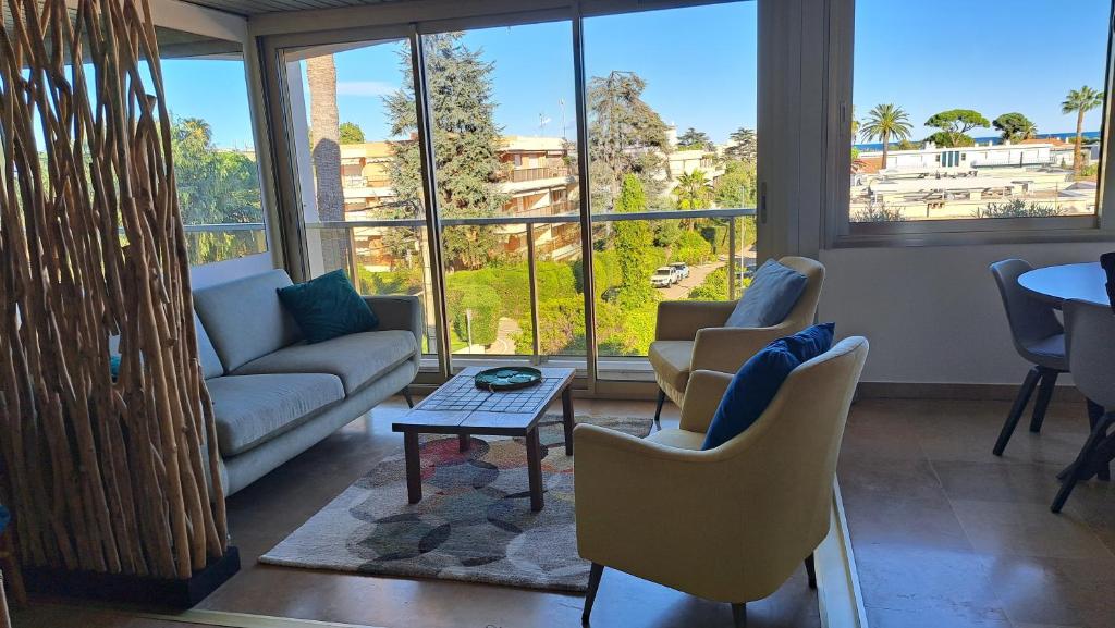 a living room with a couch and chairs and a table at sylphides mg in Antibes