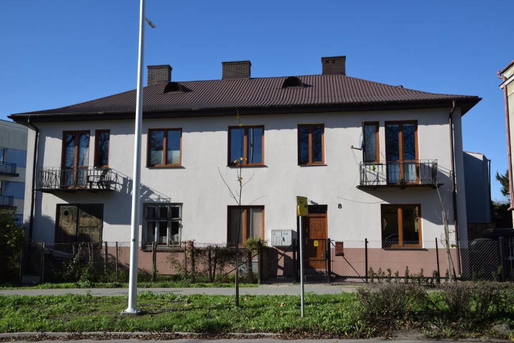 Biały dom z czarnym dachem w obiekcie Apartament Sienkiewicza 8 w mieście Zamość
