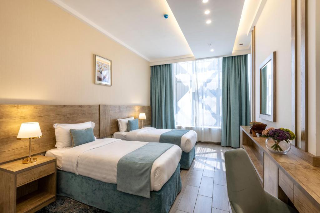 um quarto de hotel com duas camas e uma janela em Hotel 21 em Meca