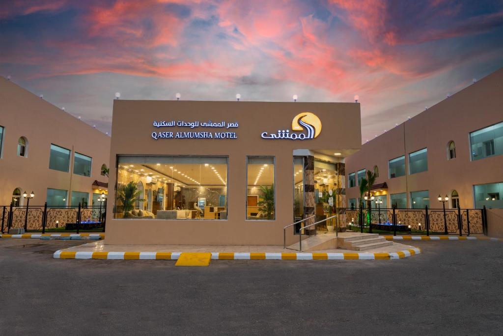 uma loja na frente de um edifício com um céu nublado em قصر الممشى للشقق الفندقية em Jazan