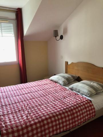 1 dormitorio con 1 cama con manta roja y blanca en Le Hameau du lac, en Marciac
