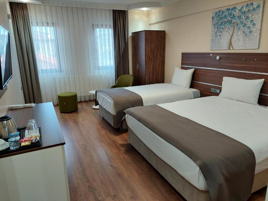 a hotel room with two beds and a television at BEYAZ İNCİ OTEL in Sivas