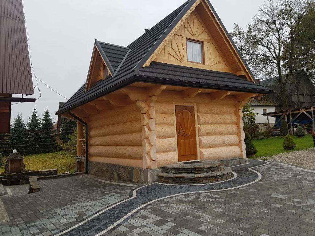 uma pequena cabana de madeira com um telhado preto em U Garczków em Witów