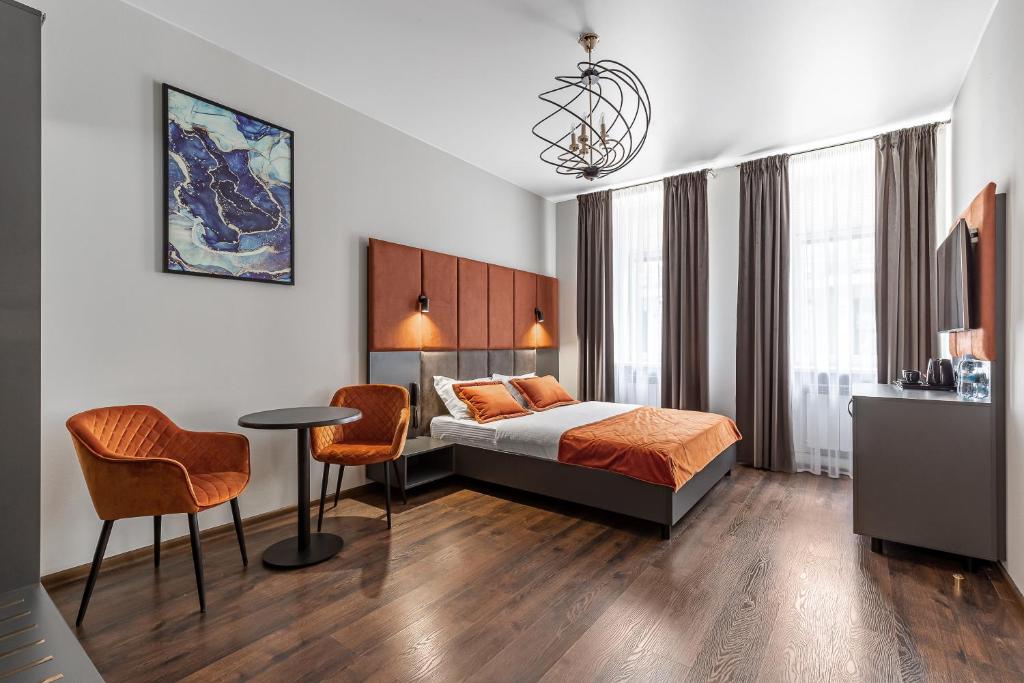 a hotel room with a bed and a table and chairs at Kievinn in Kyiv