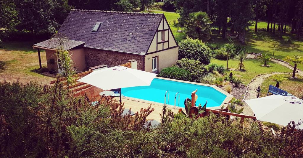 una vista aérea de una casa con piscina en Le Vieux Moulin Gites - Detached cottage with garden views and pool, en Guégon