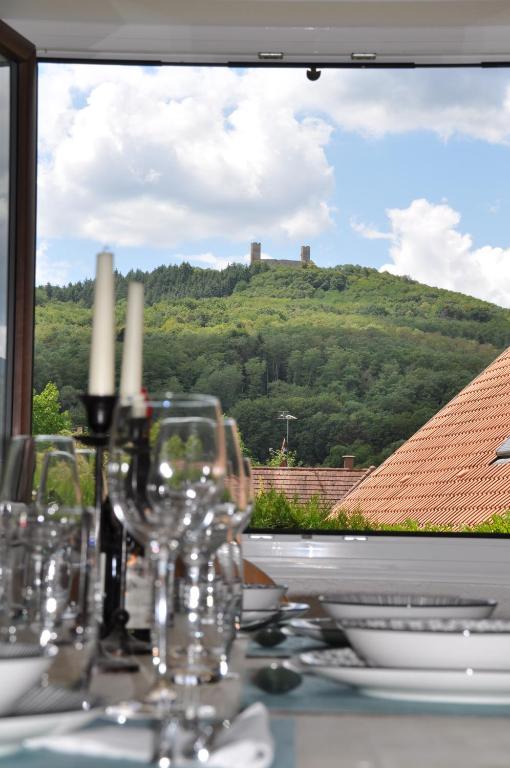 a table with wine glasses and a view of a hill at Villa sous le Tilleul in Barr