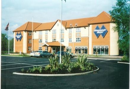 un gran edificio con un estacionamiento delante de él en Diamond Lodge, en Mánchester