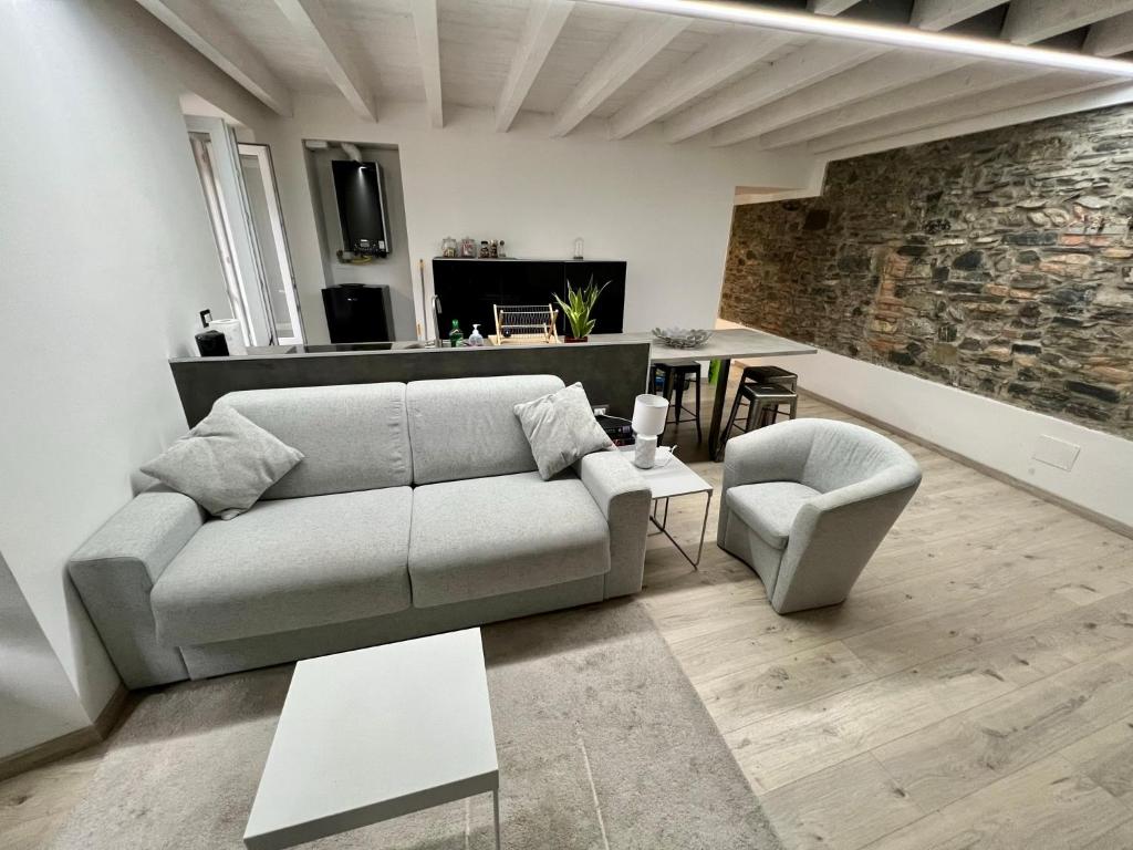 sala de estar con sofá y silla en larius apartment, en Como