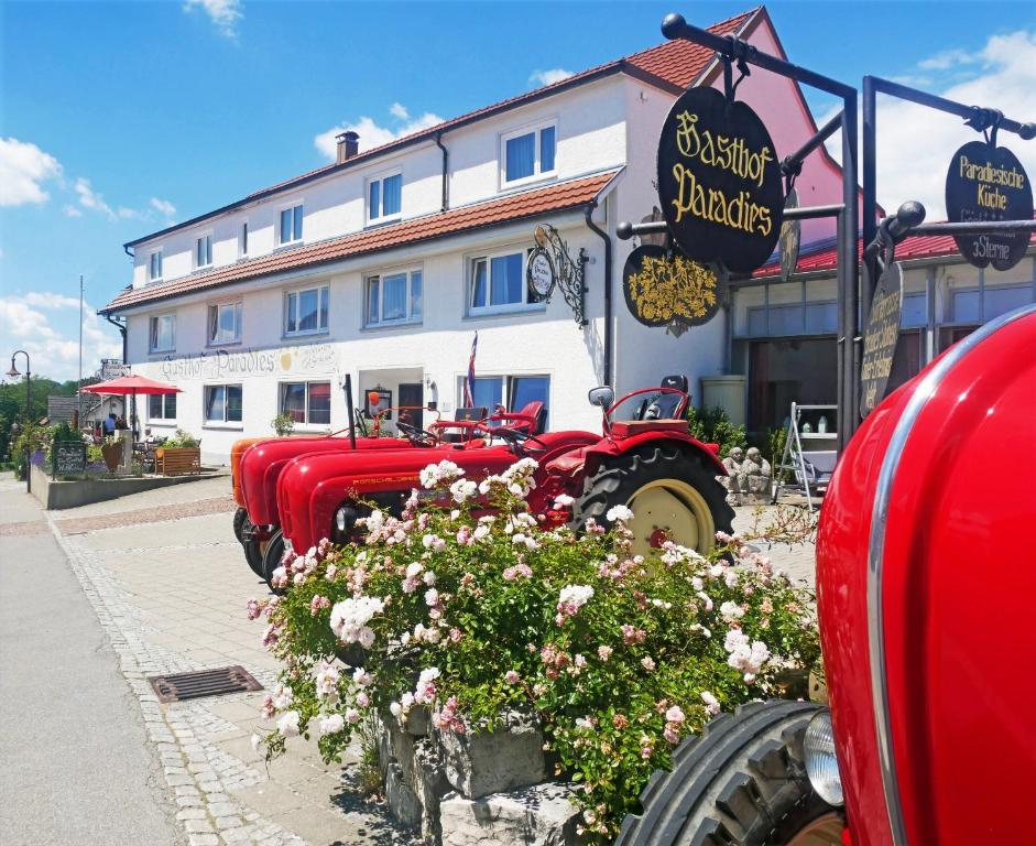 uma fila de camiões vermelhos estacionados em frente a um edifício em Adam & Eva Gasthof Paradies mit Hotel em Vogt