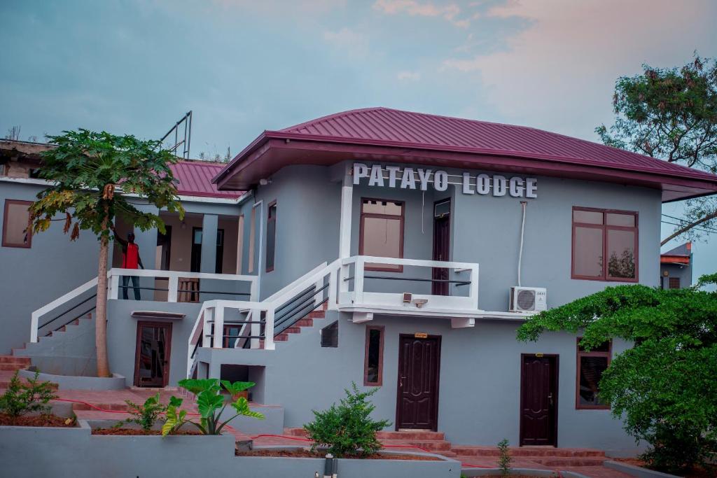 a white house with a sign that reads patriarchy house at Patayo Lodge in Kumasi