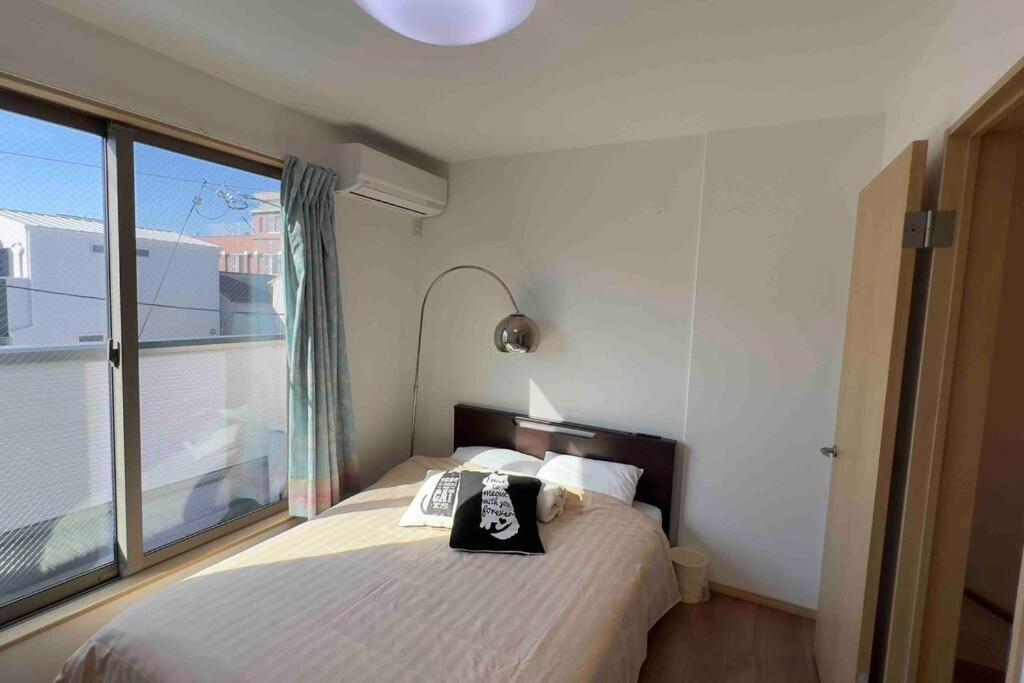 大阪市にある難波南3 room 115m2 Matsu1のベッドと大きな窓のある寝室