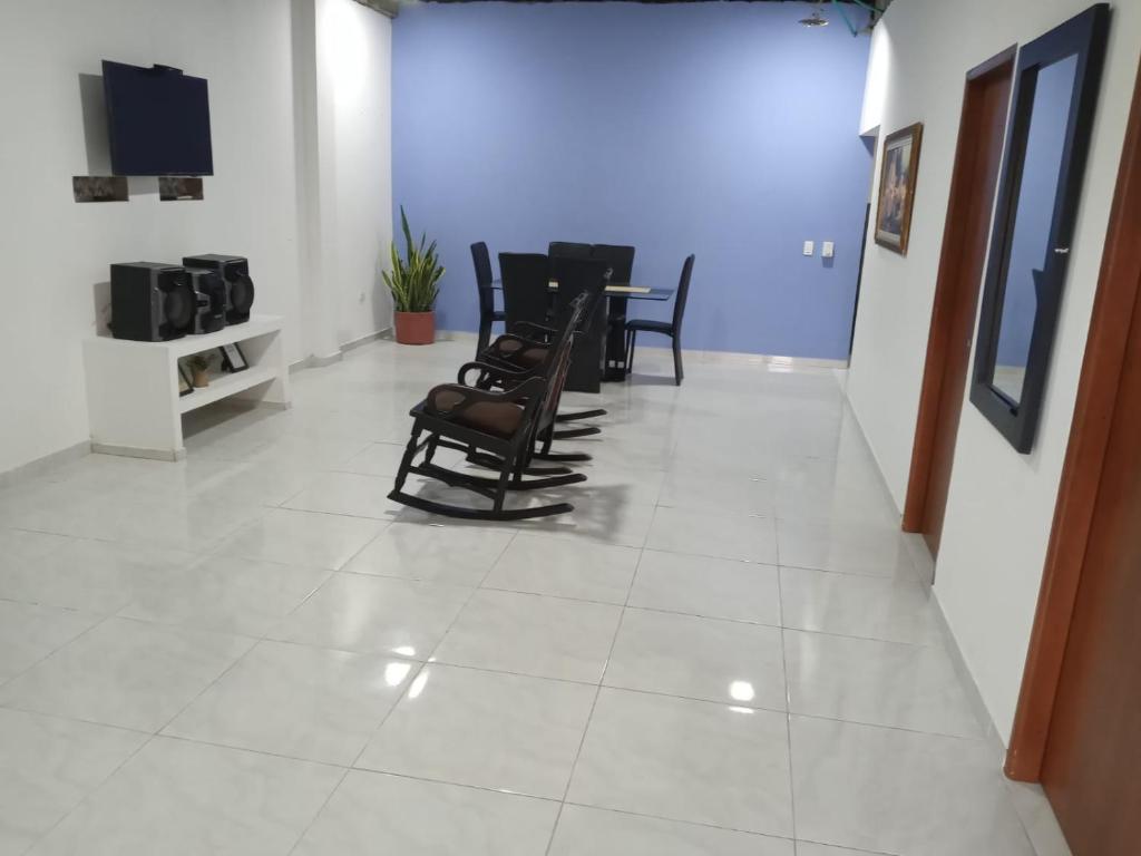 una sala de espera con sillas, mesa y TV en Cabaña Rochy, en Coveñas