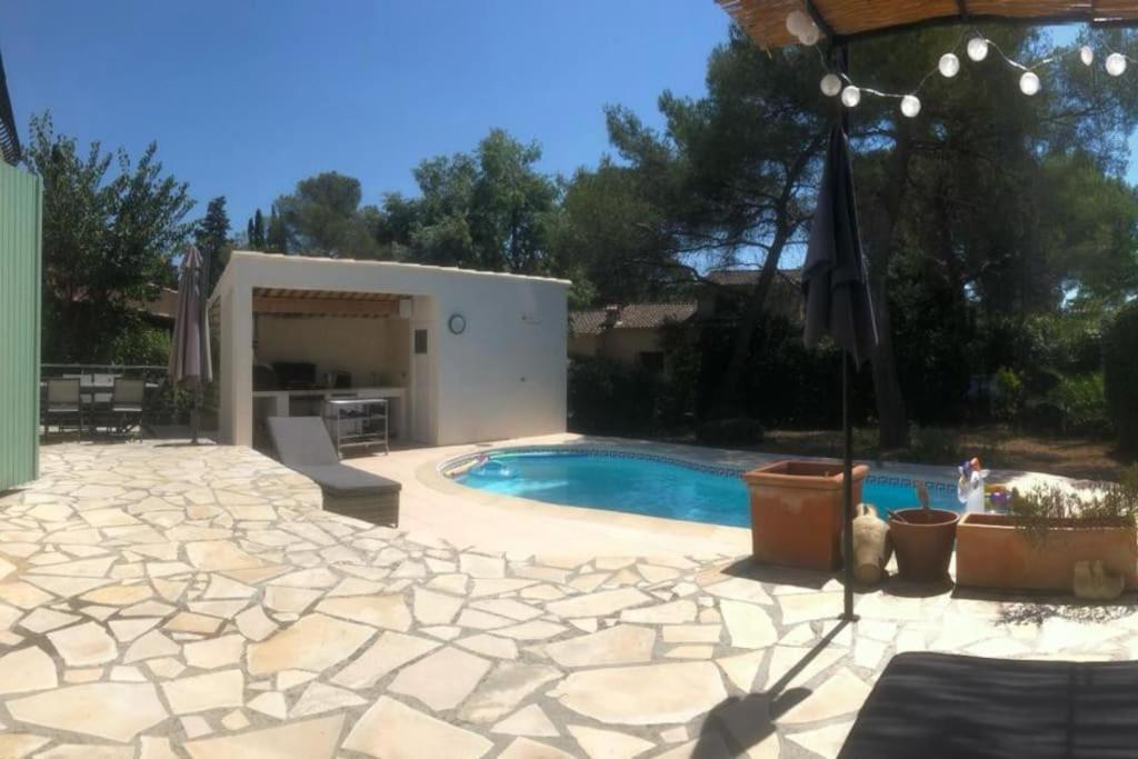 une cour arrière avec une piscine et une maison dans l'établissement Villa familiale dans un quartier résidentiel, à Saint-Raphaël