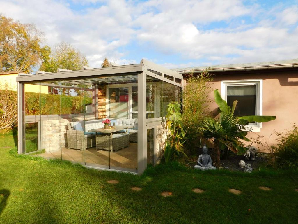 eine Glaserweiterung eines Hauses mit Garten in der Unterkunft Projekt Ferienhaus am See inkl. W-LAN, Betwäsche und Netflix in Jürgenshagen