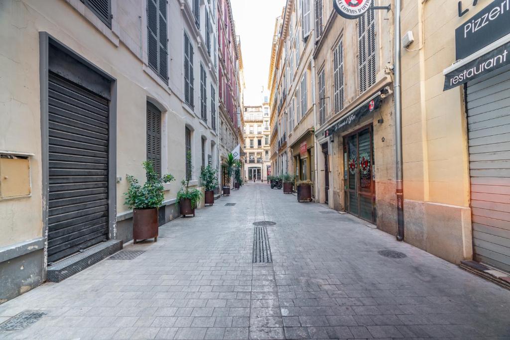 an empty street in a city with buildings at Studio inspiration hôtel standing Vieux-Port in Marseille