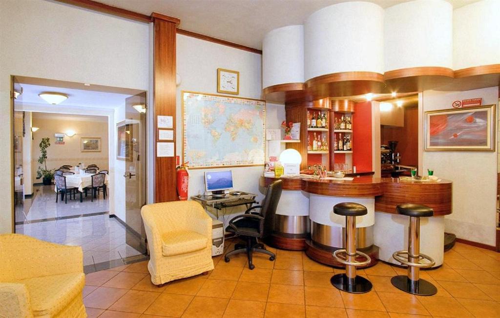 a bar in a room with a table and chairs at Piccolo Hotel in Milan