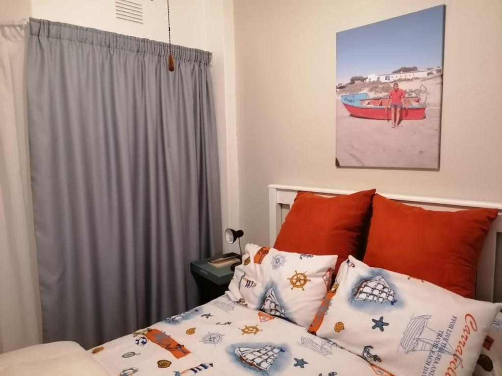 um quarto com uma cama com almofadas laranja e branca em Seeskulp 18 em Margate