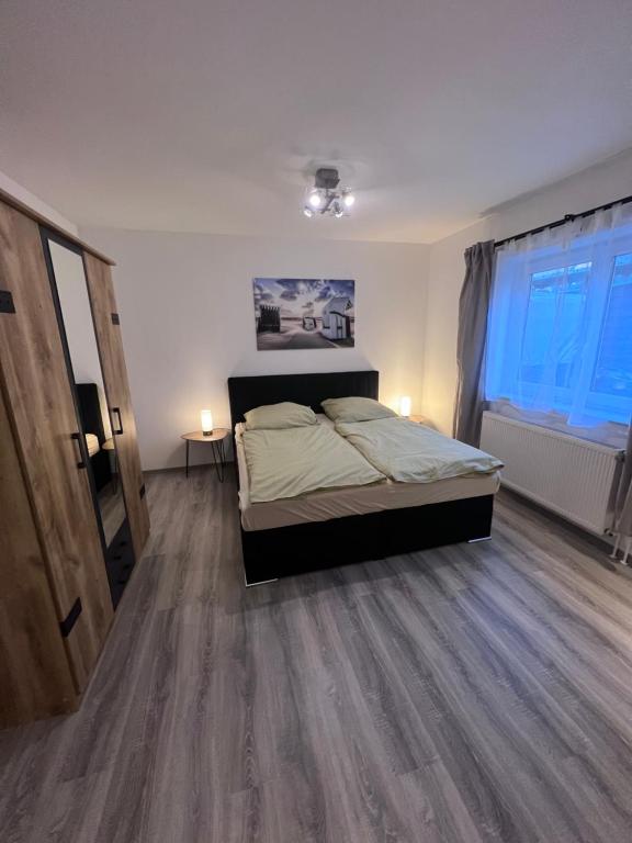 een slaapkamer met een bed en een houten vloer bij Schöne helle Ferienwohnung 64qm mit Kingsize Bett, Smart-TV, Wlan und sehr ruhige Lage in Erfurt