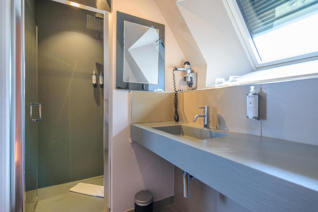 a bathroom with a sink and a mirror at Saint Georges Hotel &amp; Spa in Chalon-sur-Saône