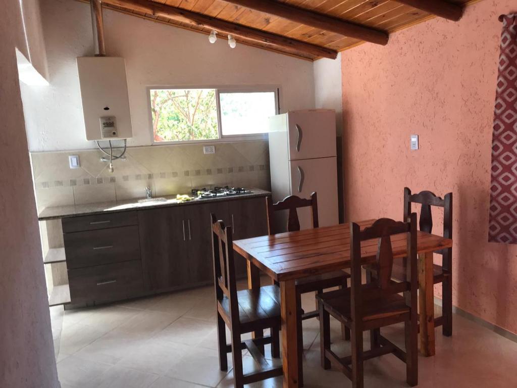 cocina con mesa de madera y sillas en una habitación en El Jacaranda 2 - Complejo en Agua de Oro